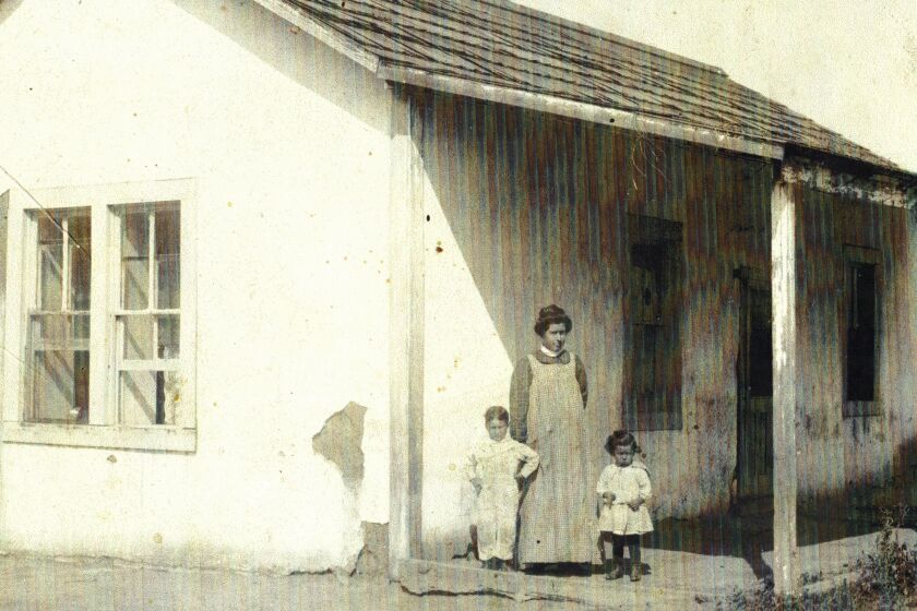 Image of a one-story house with a woman and two children standing out front