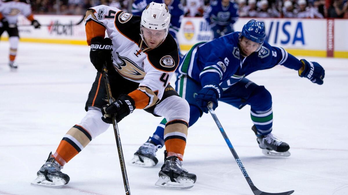 Ducks defenseman Cam Fowler vies for control of the puck with Vancouver's Luca Sbisa on March 28.