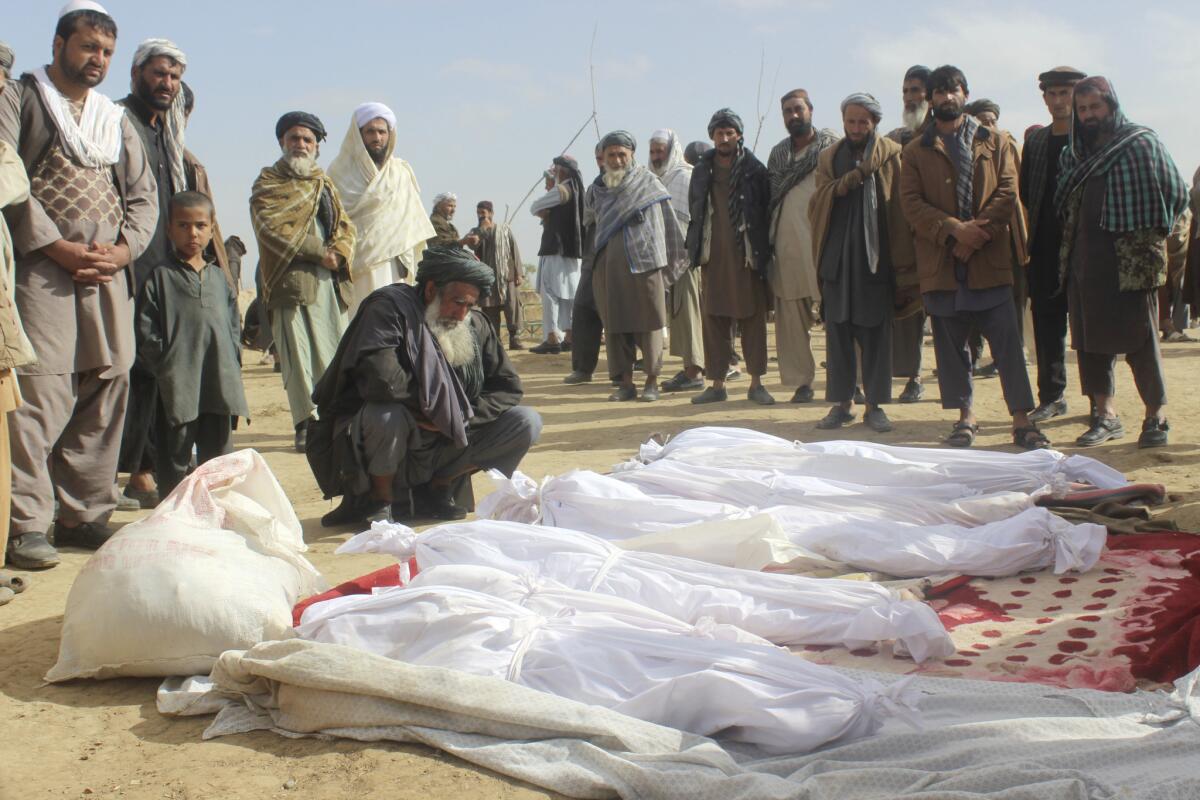 Afghans gather in November around the bodies of people killed in a battle, in Boz-e Kandahari village, Kunduz province.