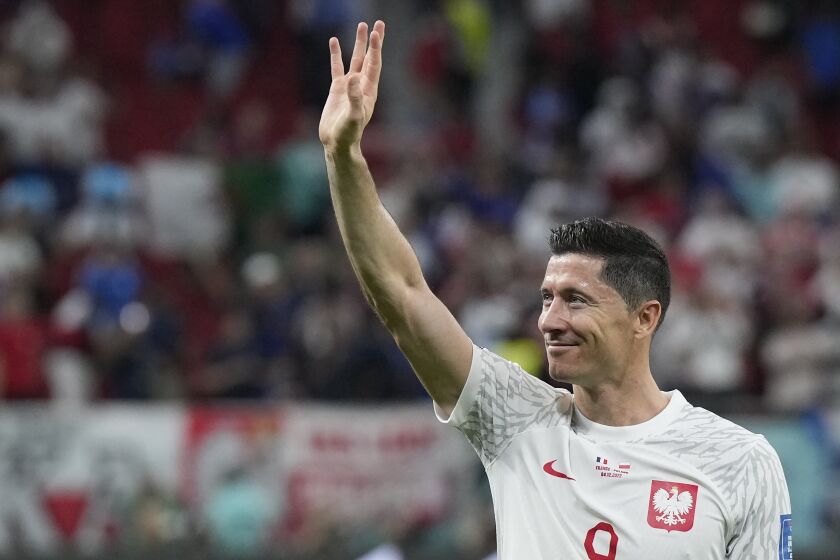 FILE - Poland's Robert Lewandowski waves after the World Cup round of 16 soccer match between France and Poland, at the Al Thumama Stadium in Doha, Qatar, on Dec. 4, 2022. The former Polish manager of Barcelona striker Robert Lewandowski went on trial Thursday Feb. 2, 2023 in Poland for allegedly having blackmailed the footballer and his wife trying to extort some euro 20 million from them. (AP Photo/Ricardo Mazalan, File)