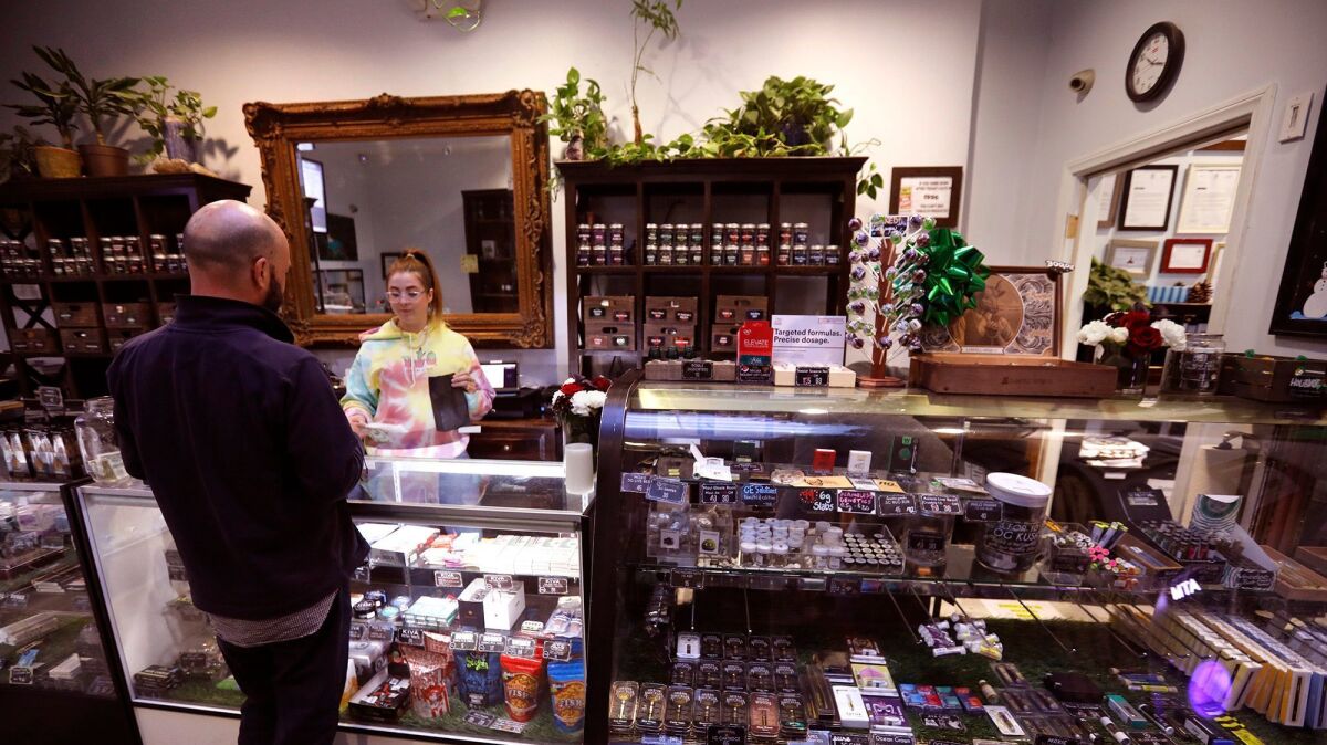 Budtender Erin Clowry fills an order at The Higher Path marijuana dispensary in Sherman Oaks on December 28, 2017.