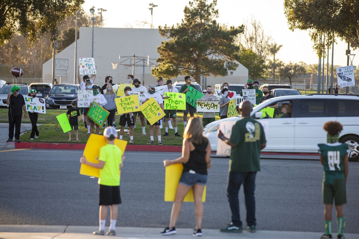 Students and family members participate in a "Let Them Play" rally at Edison High School on Friday.