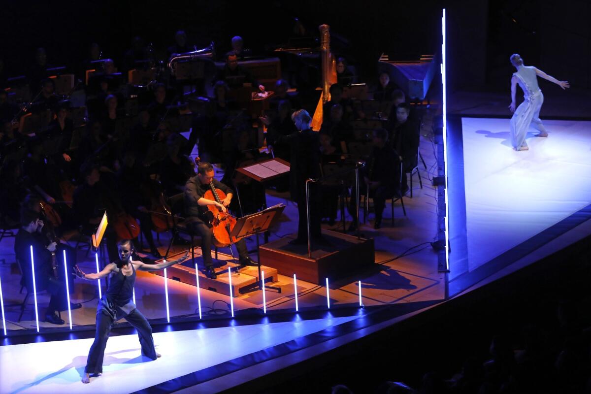 Flanked by Tero Saarinen Company dancers on the Walt Disney Concert Hall stage, cellist Timothy Loo plays his solo part with Susanna Mälkki nearby on the conductor's podium.