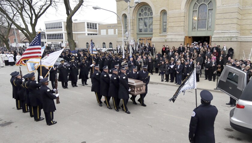 Pallbearers carry the casket of Chicago Police Cmdr. Paul Bauer to a hearse after a Mass outside the Nativity of Our Lord Catholic Church on Feb. 17, 2018, in Chicago.