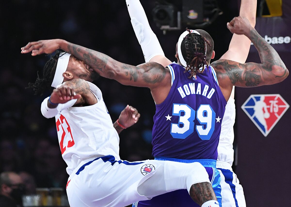 Lakers center Dwight Howard strikes Clippers forward Robert Covington in the face while battling for a rebound.