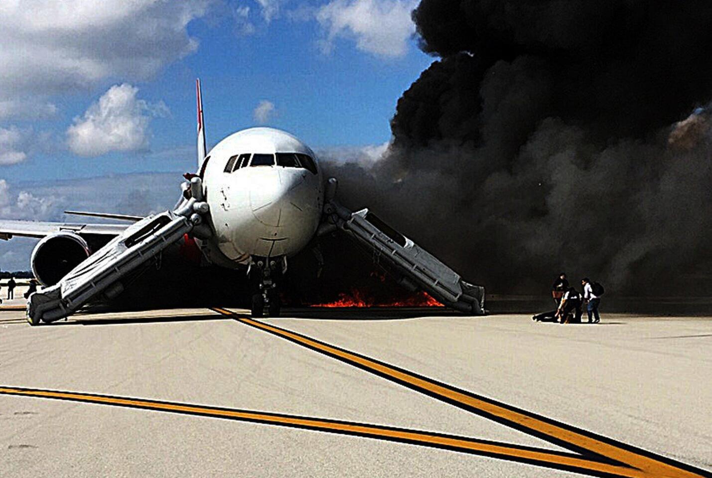 Passengers evacuate a plane that caught fire at the Fort Lauderdale/Hollywood International Airport on Oct. 29, 2015.