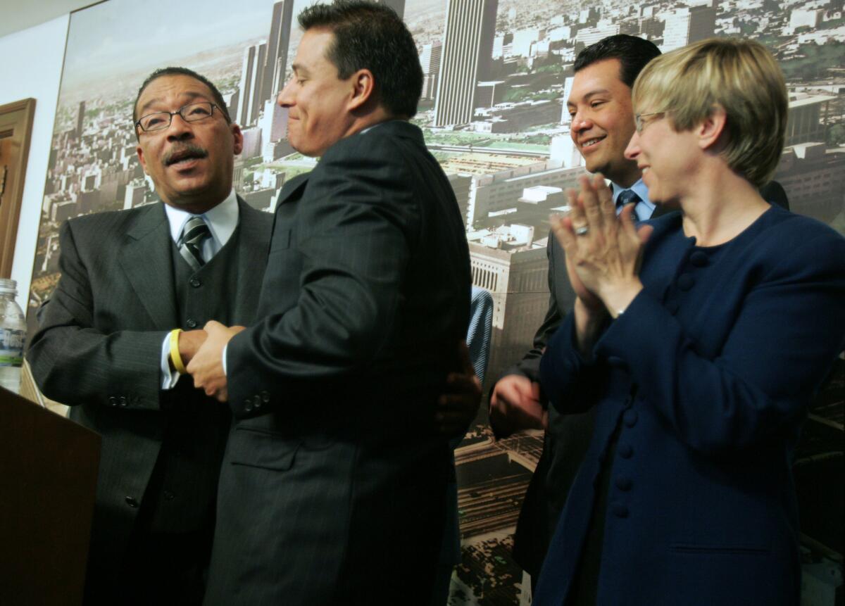 Los Angeles City Council members-elect Herb Wesson, left and Jose Huizar embrace at a news conference at City Hall before a session in 2005.