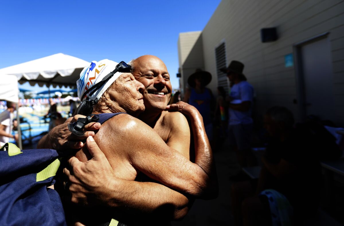 MESA, ARZ April 27, 2019: Master swimmers Maurine Kornfeld, 97, left, greets her pal Errol Graham, right, with a big hug during the USMS Spring National Championship at Kino Aquatic Center in Mesa, Arz April 27, 2019. Maurine routinely swims at several pools in the Los Angeles area and she knows Errol from the West Hollywood Aquatics pool. (Francine Orr/ Los Angeles Times)