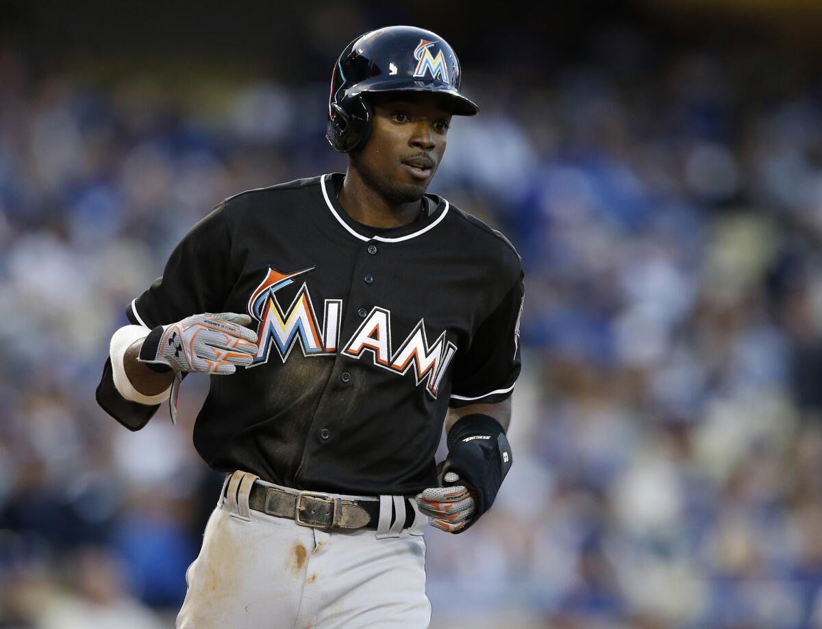Miami Marlins' Dee Gordon makes his way to the dugout after scoring against the Dodgers on April 27.