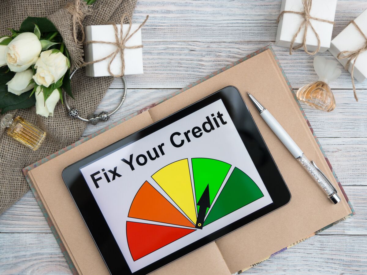 This photo illustration shows a computer tablet reading "fix your credit."