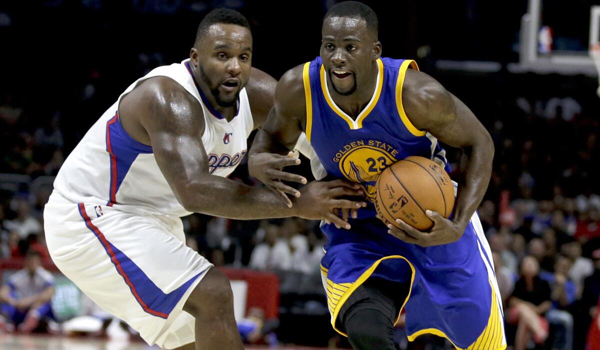 Warriors power forward Draymond Green drives around clippers power forward Glen Davis during the second half of a preseason last week at Staples Center.