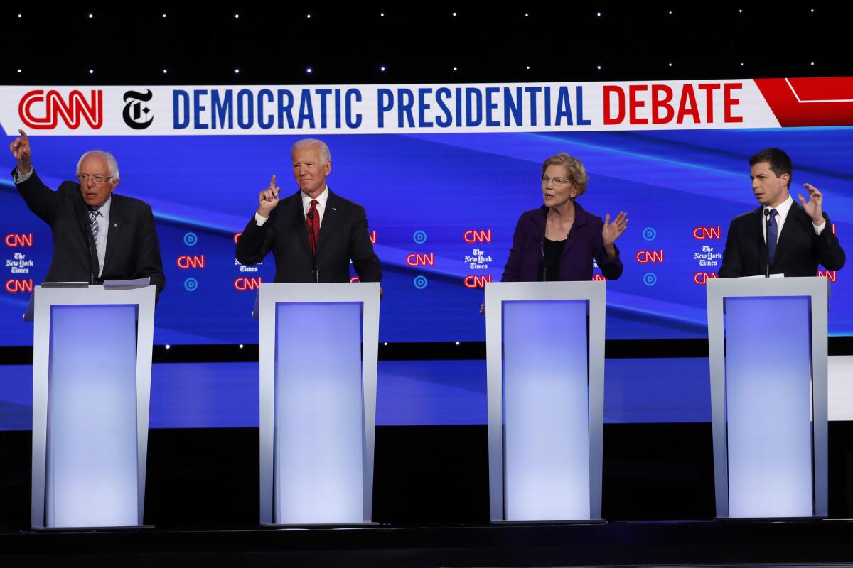 Presidential candidates Sen. Bernie Sanders (I-Vt.), left, former Vice President Joe Biden, Sen. Elizabeth Warren (D-Mass.) and South Bend, Ind., Mayor Pete Buttigieg all gesture to speak during a Democratic primary debate hosted by CNN/New York Times at Otterbein University on Tuesday in Westerville, Ohio.