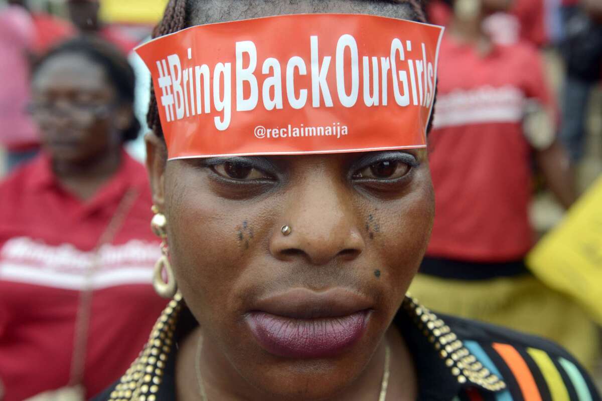 A woman with a sticker on her head bearing the slogan "Bring back our girls" marches for the release of the 272 abducted schoolgirls.