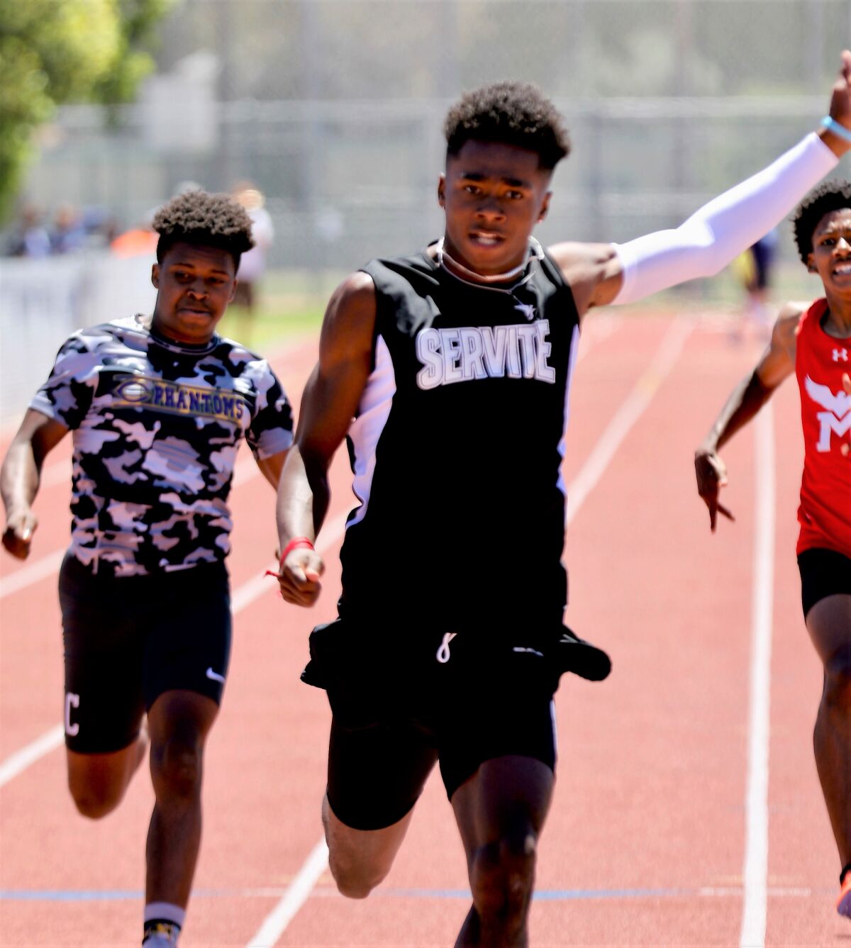 Servite's Max Thomas raises his arm in triumph after winning the 200-meter dash at the CIF-SS Division 3 track finals.