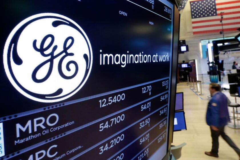FILE - In this June 12, 2017, file photo, the General Electric logo appears above a trading post on the floor of the New York Stock Exchange. General Electric says it will take a $6.2 billion after-tax charge in the fourth quarter tied to its review and reserve testing of GE Capitalâs run-off insurance portfolio. GE Capital will also suspend its dividend to GE for the foreseeable future. (AP Photo/Richard Drew, File)