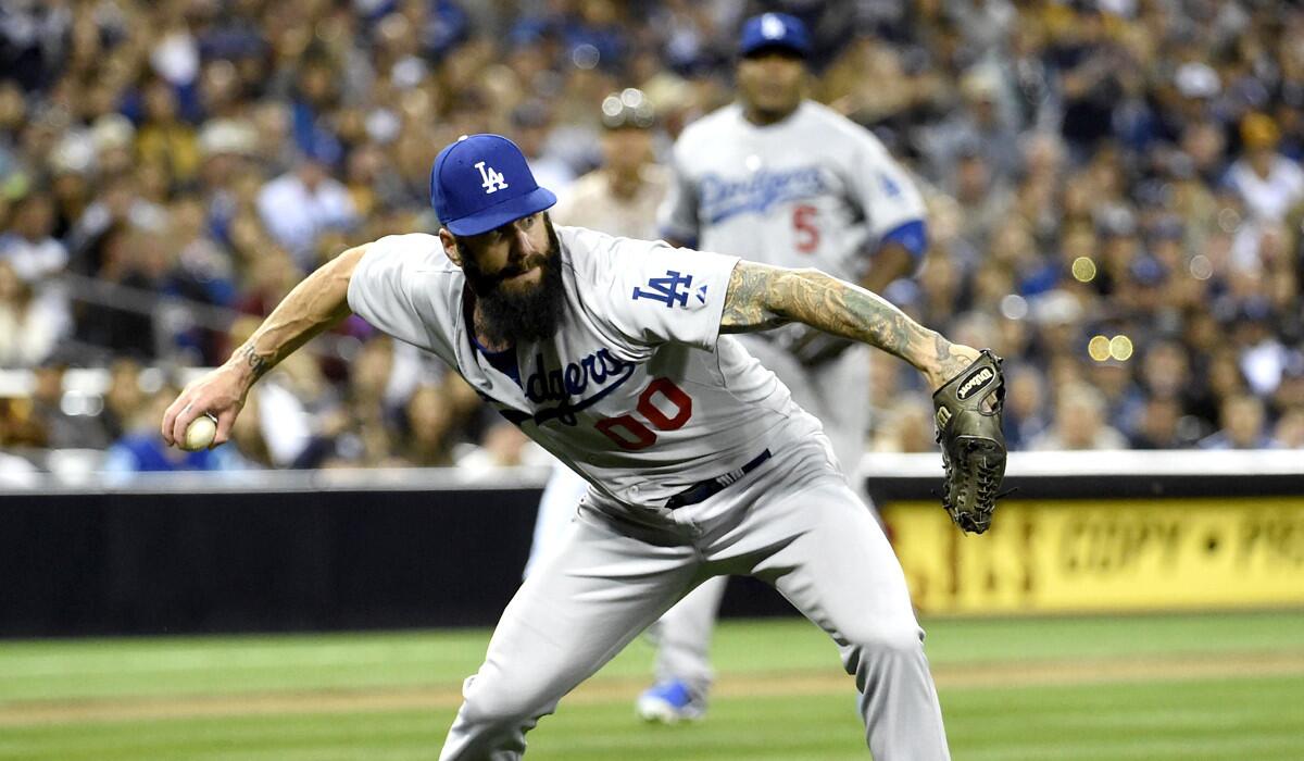 Reliever Brian Wilson, making a throw after fielding a bunt against the Padres, is one of many major leaguers who have played for the Dodgers and Giants.