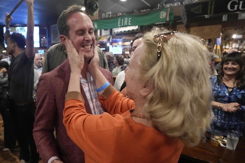El político de Delaware Schuyler VanValkenburg, a la izquierda, recibe una muestra de afecto de una seguidora en una fiesta electoral el martes 7 de noviembre de 2023 en Glenn Allen, Virginia. (AP Foto/Steve Helber)