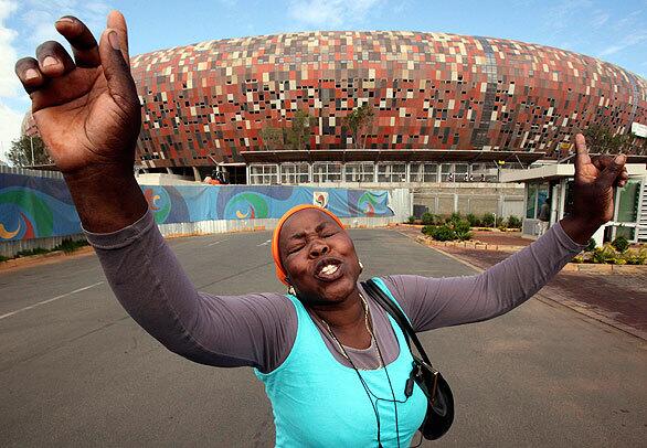 Sophia Thlagane, leader of the informal traders who sell food to construction workers on the site of the Soccer City Stadium, reacts in protest to their eviction from the site. The traders were served notice to vacate the premises Friday, and police have moved in to enforce their eviction.