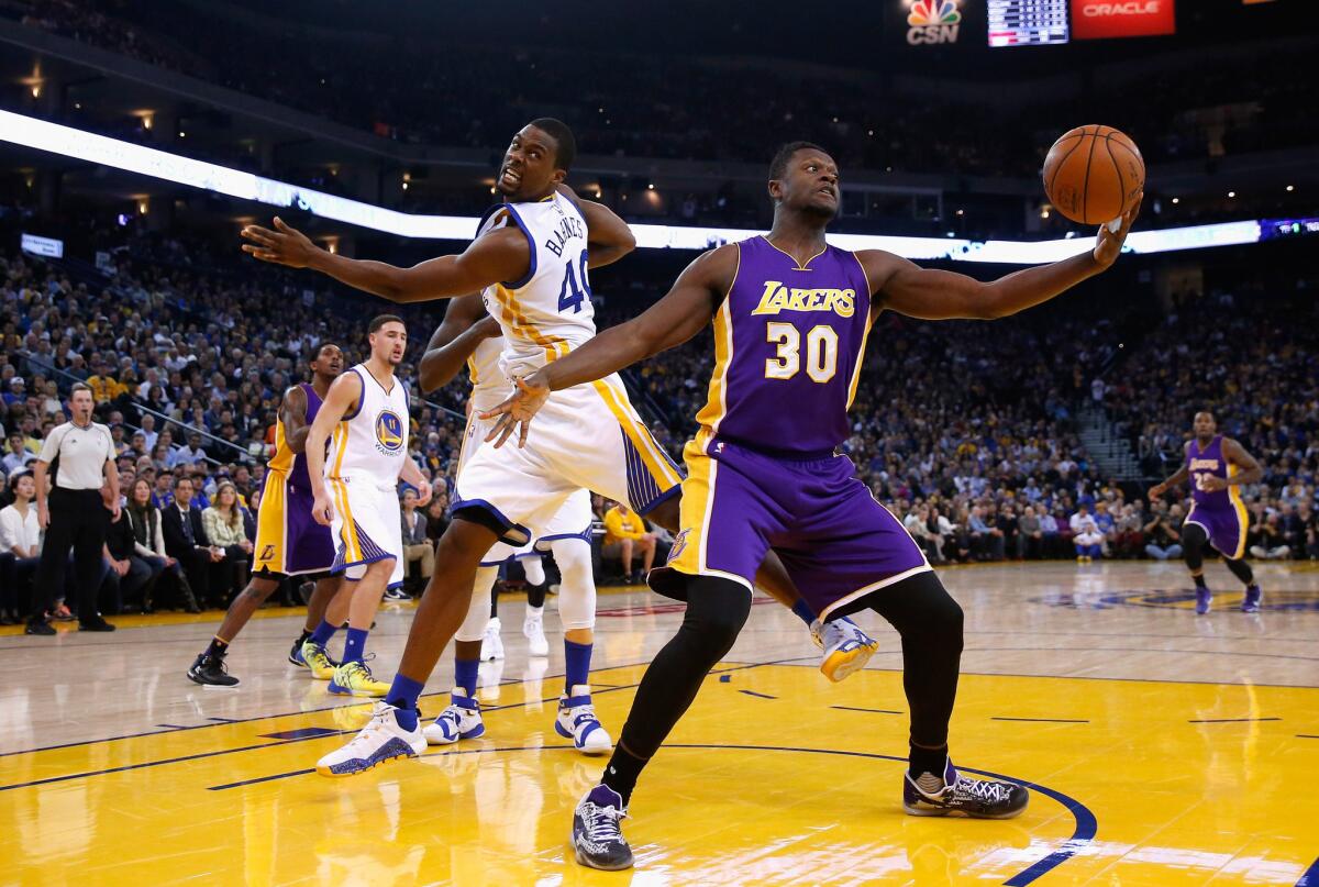 Lakers forward Julius Randle gets in front of Warriors forward Harrison Barnes to grab a loose ball during a game against Golden State on Jan. 14.