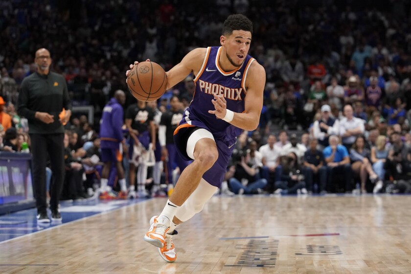 FILE - Phoenix Suns guard Devin Booker drives to the basket during Game 3 of an NBA basketball second-round playoff series against the Dallas Mavericks, May 7, 2022, in Dallas. Booker agreed to a four-year contract extension early Friday, July 1. (AP Photo/Tony Gutierrez, File)