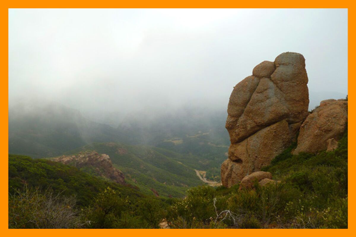Rocky outcroppings stand out against a foggy day in the mountains.
