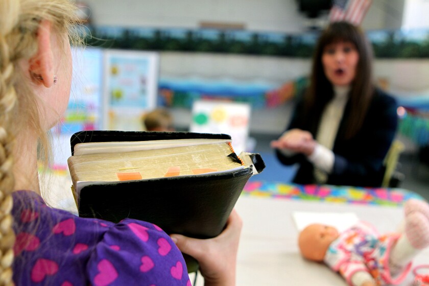 A child holds up a Bible during a Sunday school class in Santa Monica in 2014.