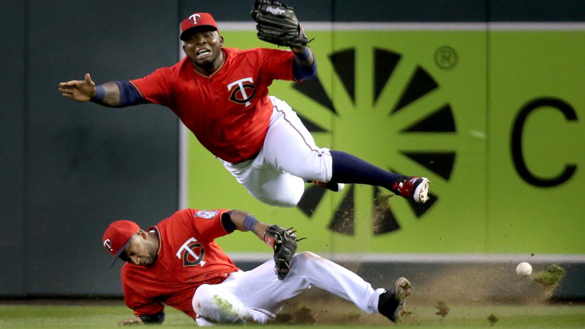 Twins right fielder Miguel Sano, top, and second baseman Eduardo Nunez collide in right field while chasing a fly ball hit by Angels third baseman Yunel Escobar during the fourth inning.