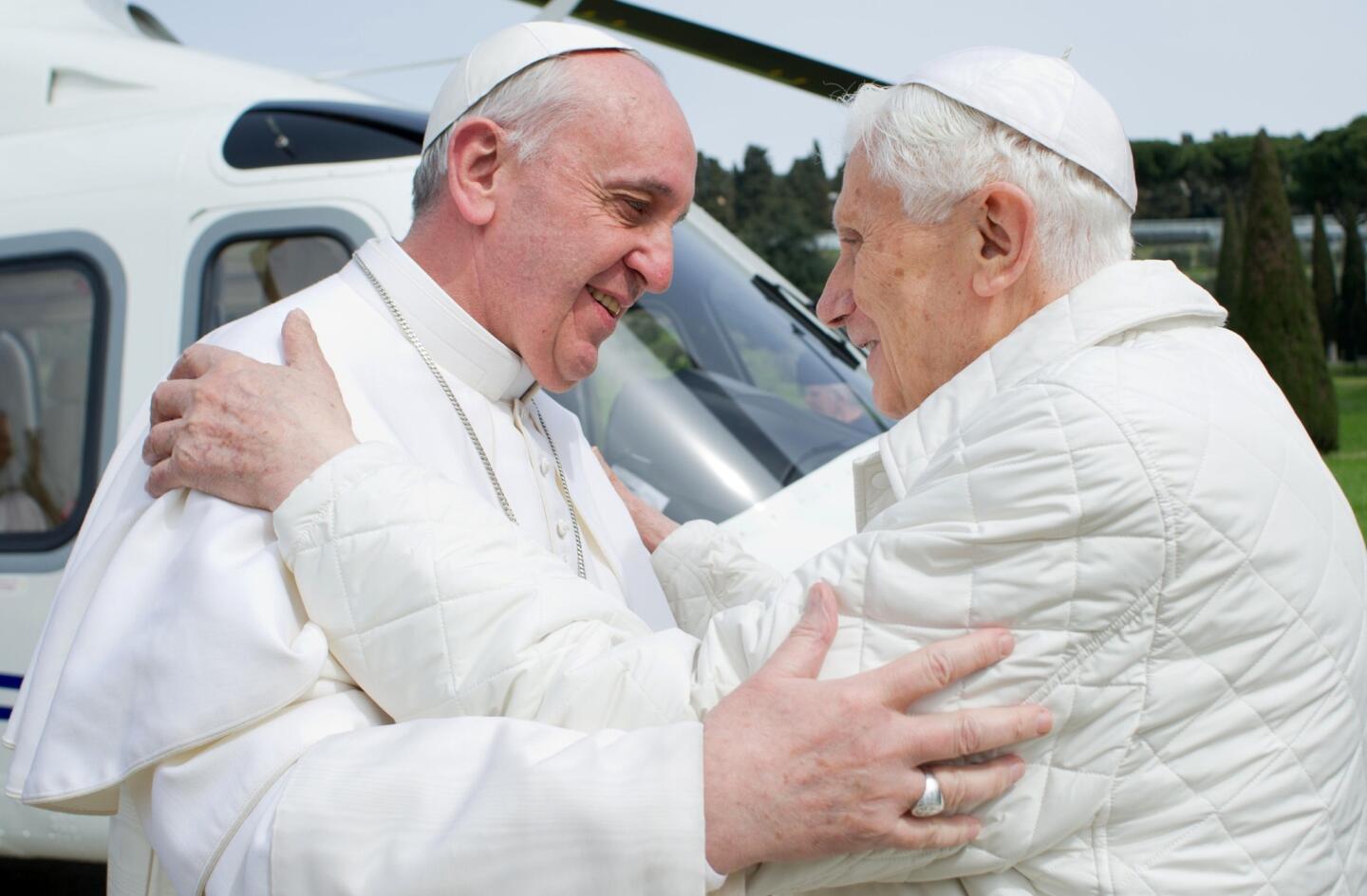 This handout picture released by the Vatican press office on March 23, 2013 shows "pope emeritus" Benedict XVI (R) greeting Pope Francis upon his arrival at the heliport in Castel Gandolfo. Pope Francis prepared to go face to face with his predecessor Benedict XVI on Saturday in a historic meeting between two men with very different styles but important core similarities. Birthday: April 16, 1927