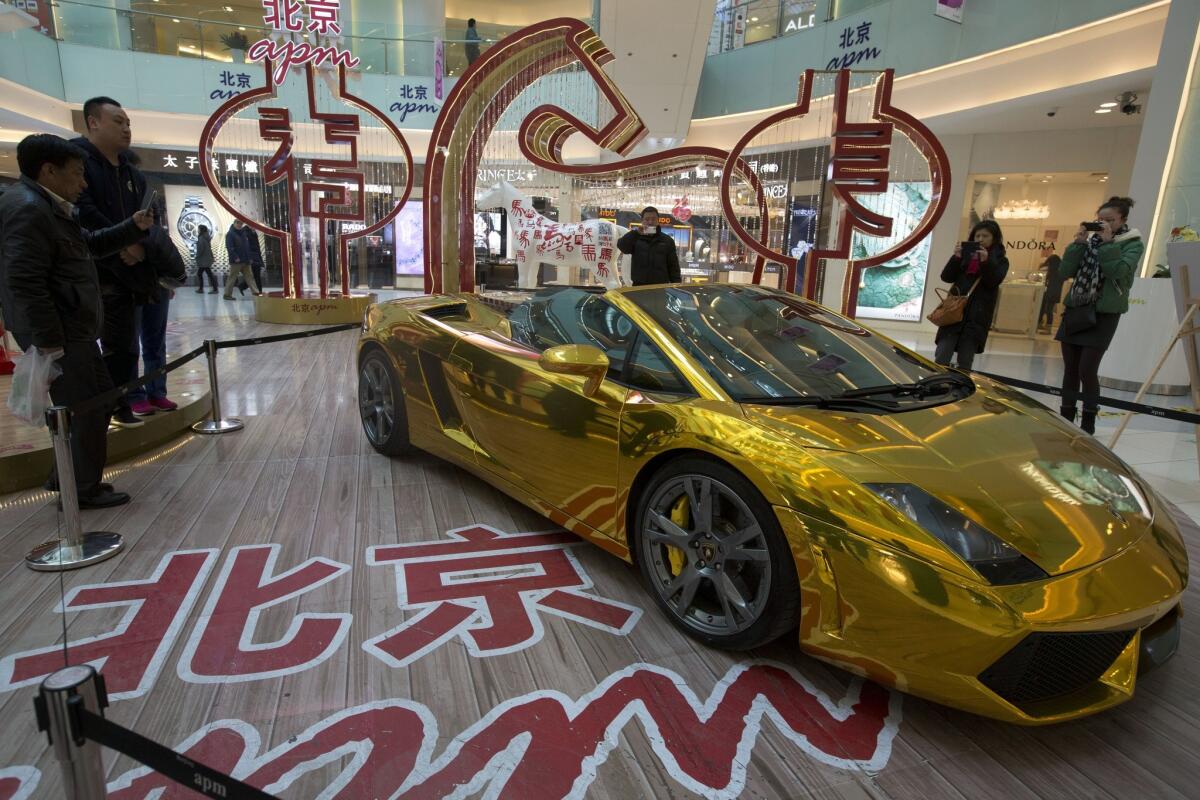 A gold Lamborghini sports car, with a price tag of $808,000, is displayed in a mall in Beijing.