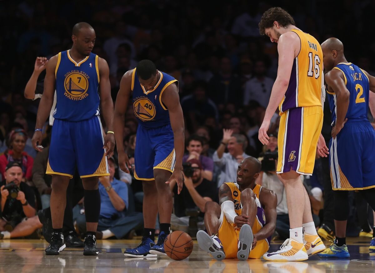Kobe Bryant holds his lower leg after suffering an apparent injury during the second half of the Lakers' 118-116 win over the Golden State Warriors.