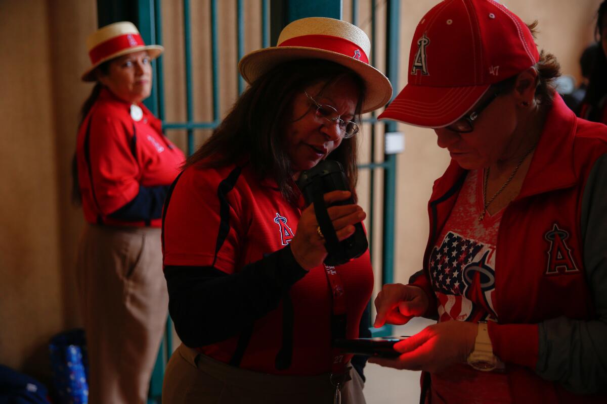 Genevieve Hyland, of Anaheim, scans a ticket displayed on the screen of a phone at the entrance to Angel Stadium on the Angel's Opening Day on Thursday.