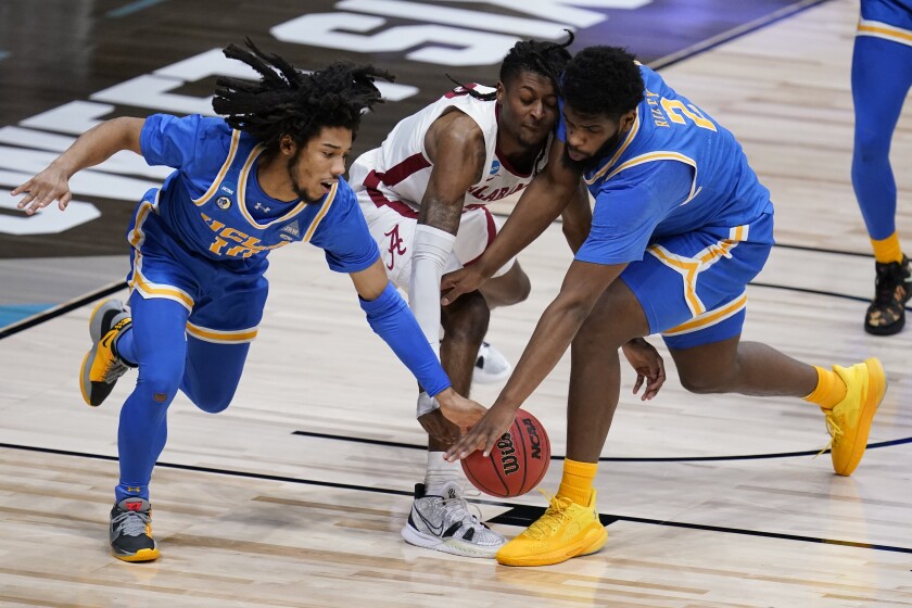 UCLA's Tyger Campbell, left, and Cody Riley battle for a loose ball with Alabama's John Petty Jr.