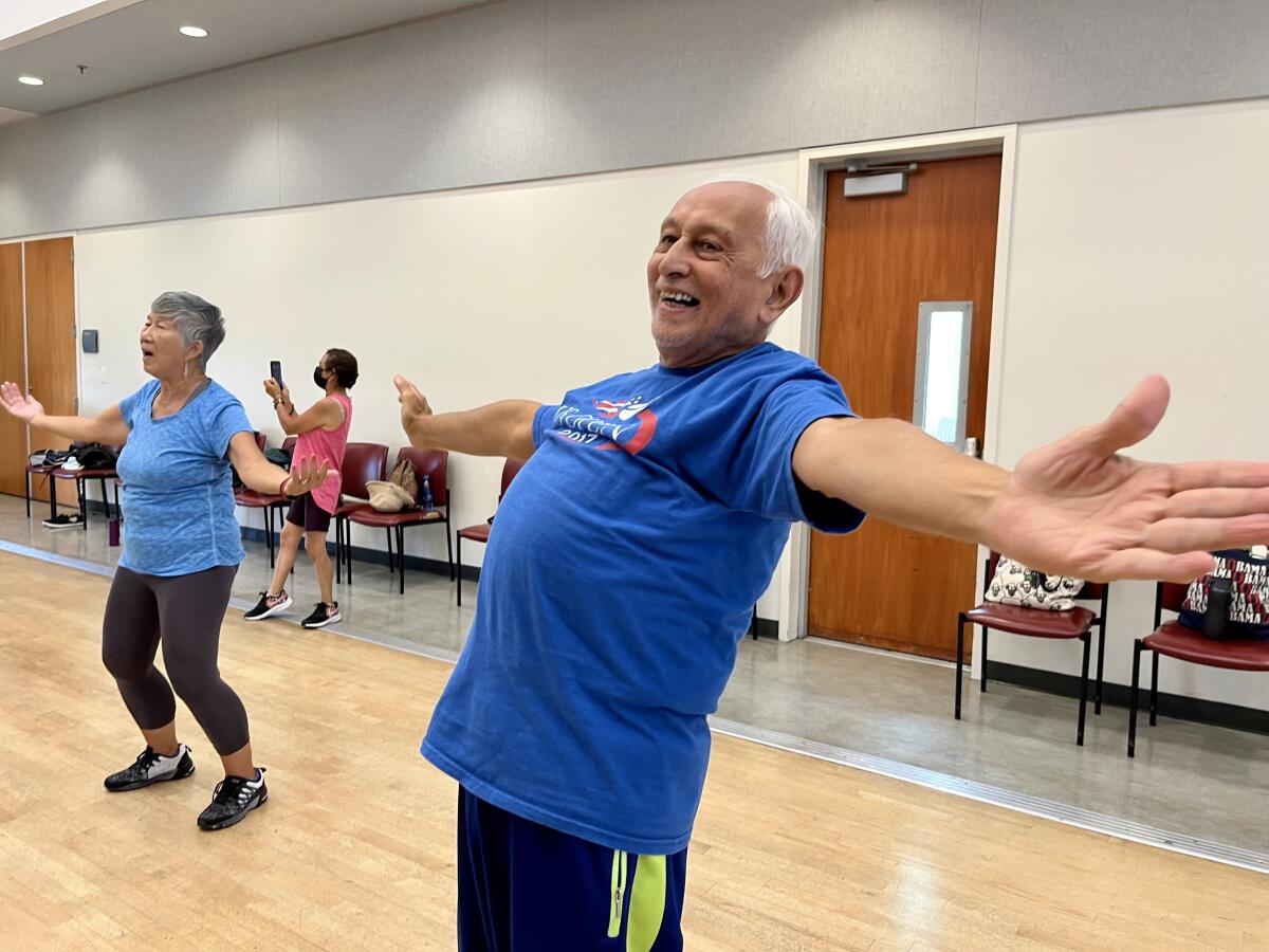 Seniors raise their arms in a dance class