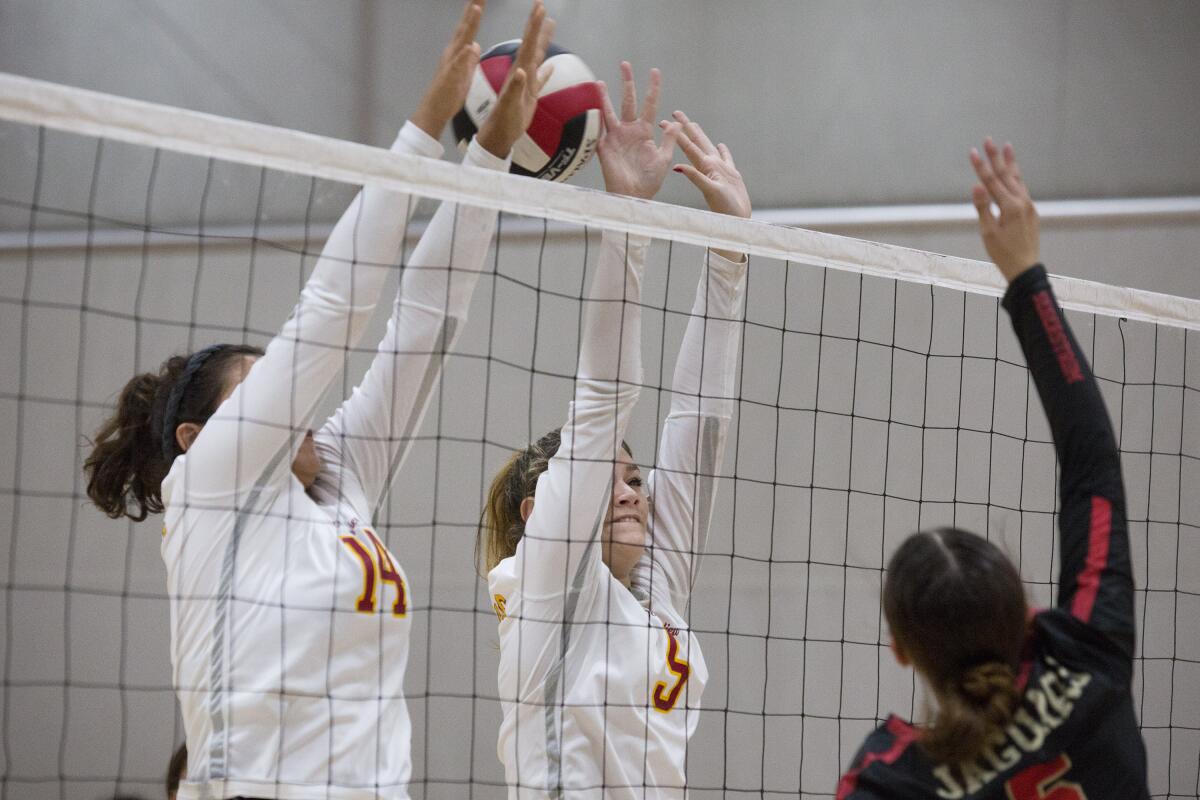 Ocean View's Dana Abascal, left, and Karlee Caldwell block a spike by Segerstrom's Arianna Carbajal in a Golden West League match on Tuesday.