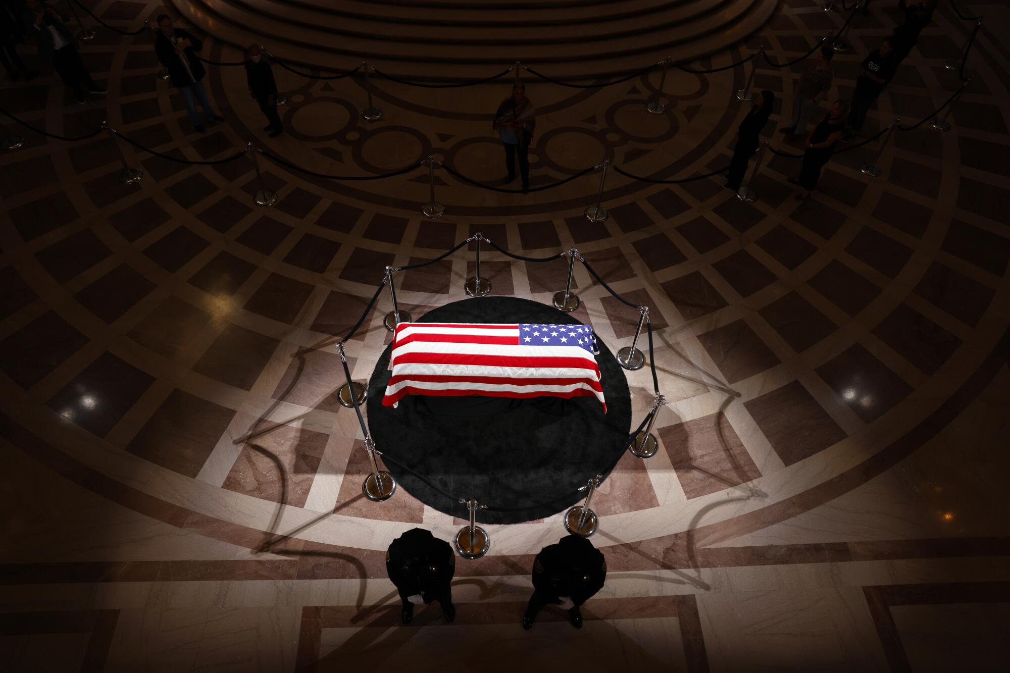 A flag-covered coffin on a dais.