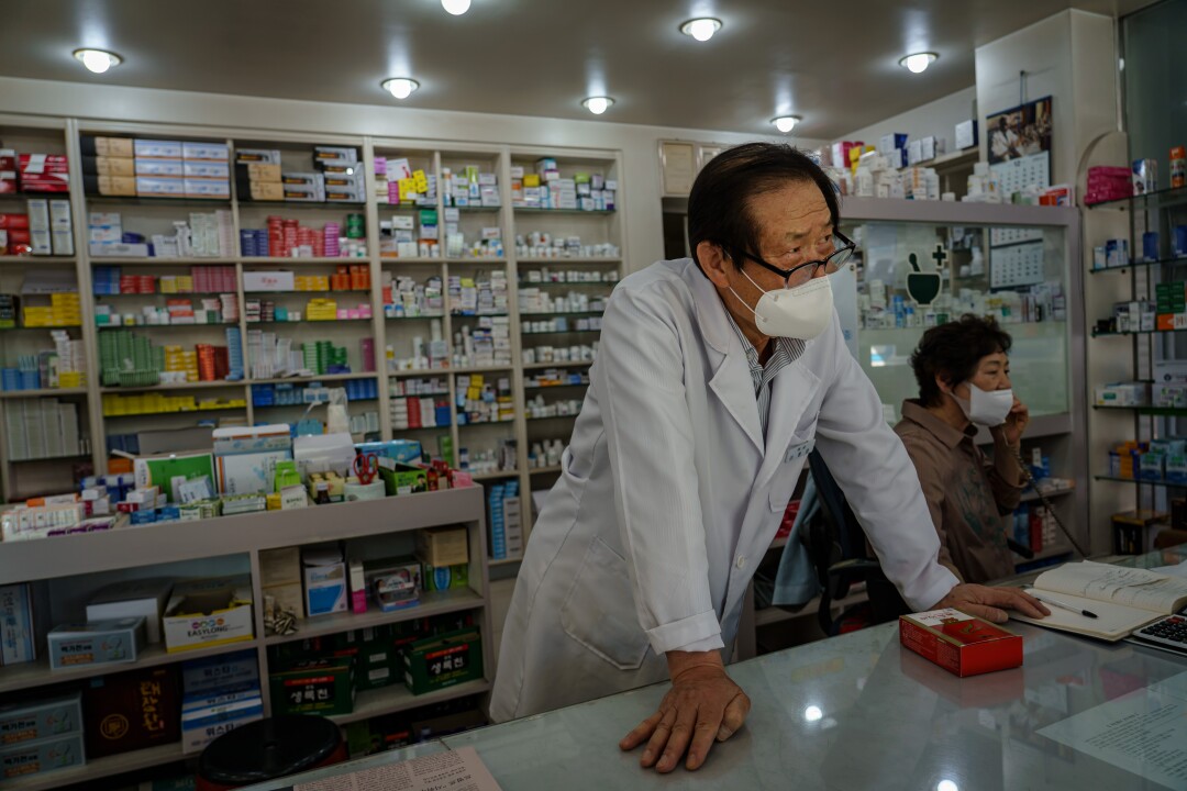 Lee Jong-ho, a pharmacist, works behind the counter in Chuncheon.