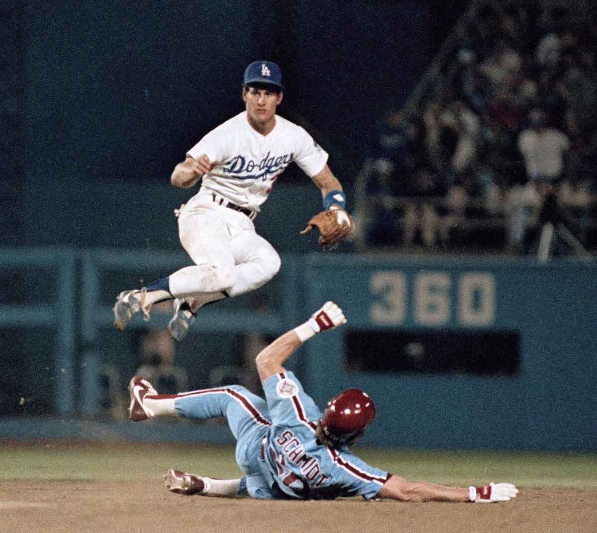 Steve Sax leaps over Mike Schmidt during the 1983 season. 