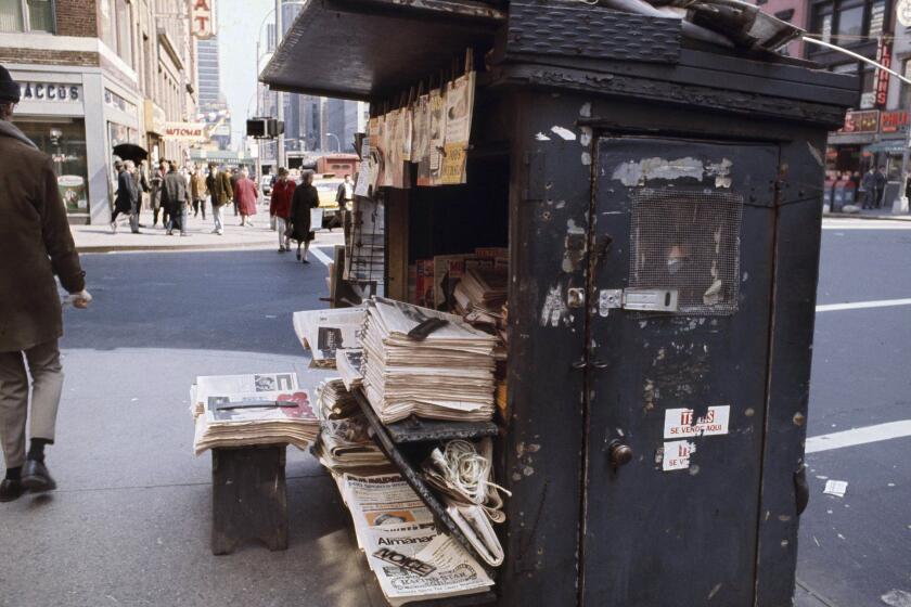Bundles of newspapers are stacked up at a newsstand in the midtown section of New York, in 1970. Exact date is unknown. (AP Photo)