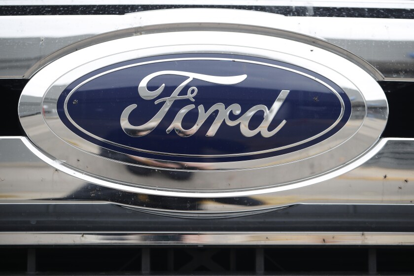 FILE - In this Oct. 20, 2019, file photograph, the company logo shines off the grille of an unsold 2019 F-250 pickup truck at a Ford dealership in Littleton, Colo. Ford Motor Co. posted a stronger-than-expected third-quarter net profit, the company announced Wednesday, Oct. 28, 2020, as demand for cars and trucks recovered from coronavirus shutdowns and the company sold more high-margin trucks. (AP Photo/David Zalubowski, File)