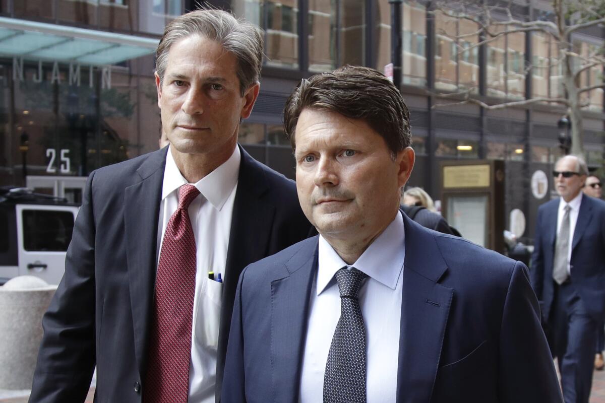 Devin Sloane, right, arrives at federal court in Boston for his sentencing last year. Citing the COVID-19 pandemic, Sloane asked a judge, unsuccessfully, to release him from prison early.