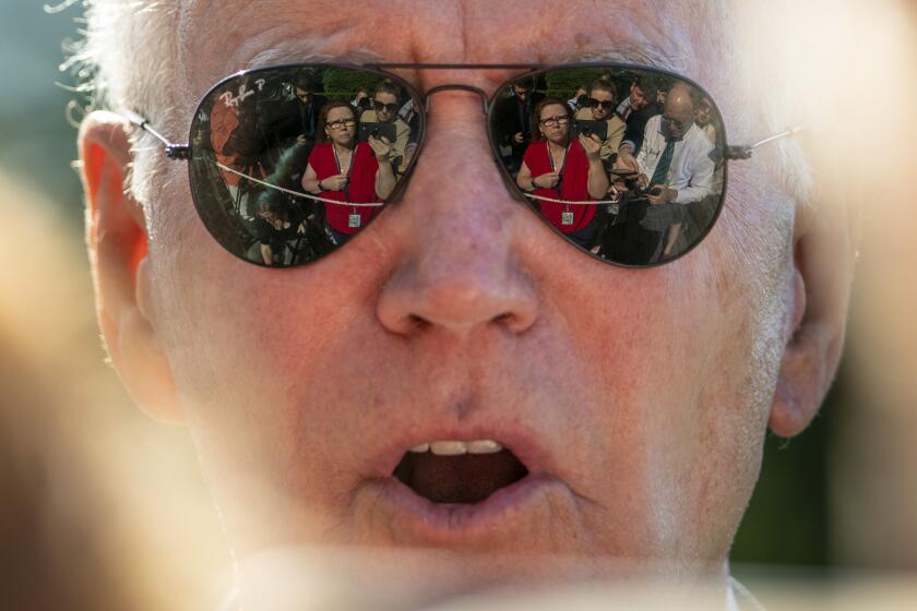 NBC Senior White House Correspondent Kelly O'Donnell, Reuters White House Reporter Steve Holland, right, and other members of the media are visible in the sunglasses of President Joe Biden as he speaks on the South Lawn of the White House in Washington, Monday, May 30, 2022, after returning from Wilmington, Del. (AP Photo/Andrew Harnik)
