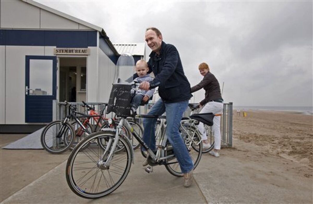 Voters react outside a polling station at a police post on the beach, after casting their ballots in general elections in Noordwijk, Netherlands, Wednesday, June 9, 2010. Voters go to the polls in elections offering a choice between a Labor Party preaching traditional Dutch tolerance and a slew of right-leaning parties advocating a crackdown on immigration. The free-market VVD party leads polls thanks to its strong economic credentials. (AP Photo/Cynthia Boll)