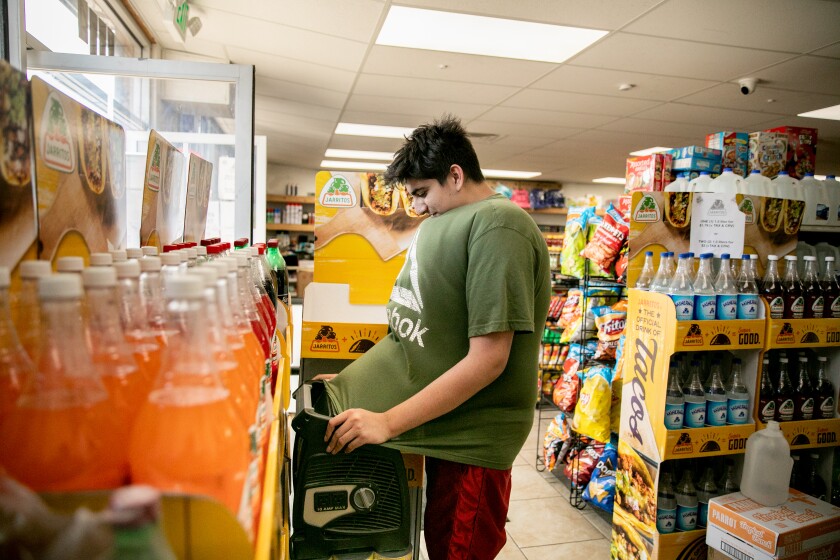 Joseph Kassab cools off over a portable fan in his family's store.