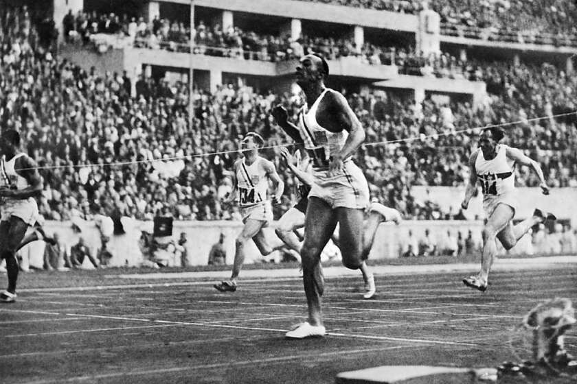 Jesse Owens crosses the finish line to win the 100-meter dash at the 1936 Olympics.