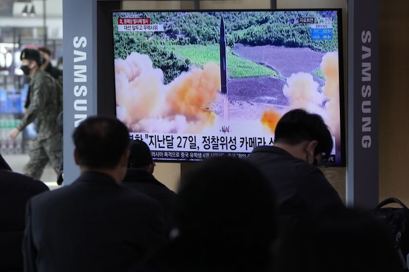 People watch a TV showing a file image of North Korea's missile launch during a news program at the Seoul Railway Station in Seoul, South Korea, Saturday, March 5, 2022. North Korea on Saturday fired a suspected ballistic missile into the sea, according to its neighbors' militaries, apparently extending its streak of weapons tests this year amid a prolonged freeze in nuclear negotiations with the United States. (AP Photo /Ahn Young-joon)