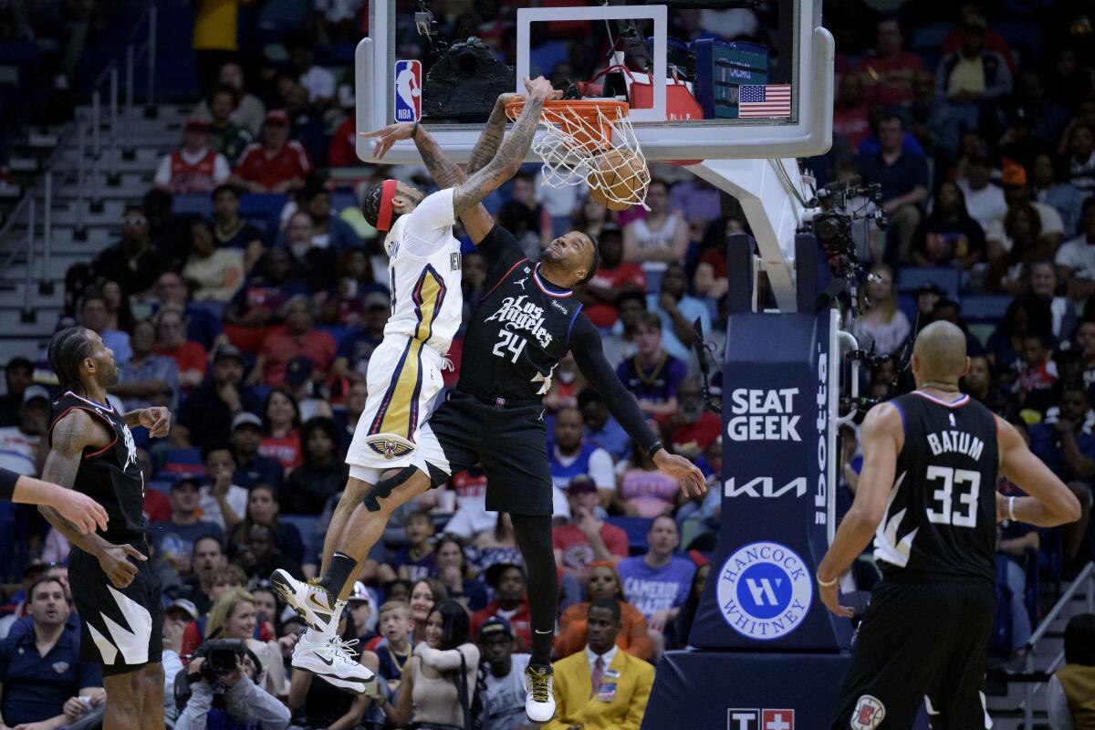 The Pelicans' Brandon Ingram dunks on the Clippers' Norman Powell during the first half April 1, 2023. 