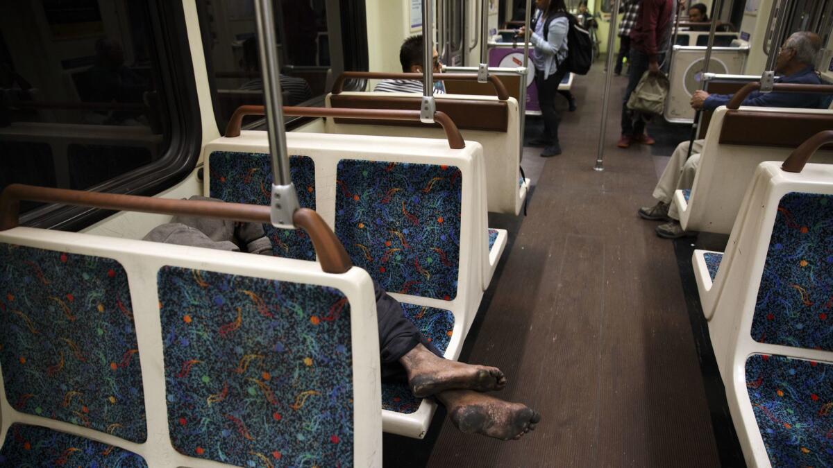 A homeless man sleeps on a Metro Red Line train nearing Los Angeles Union Station last year.