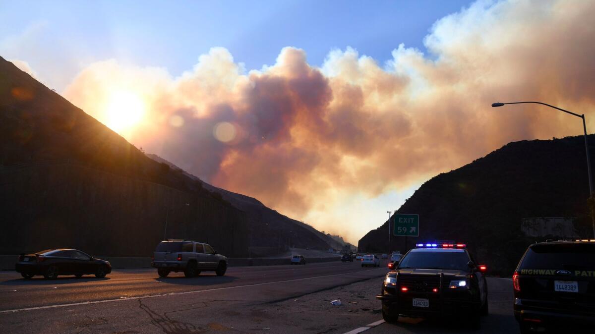 Smoke from the Skirball fire rises above the 405 Freeway in Los Angeles. Air quality concerns have closed the nearby Getty museum and the Skirball Cultural Center.