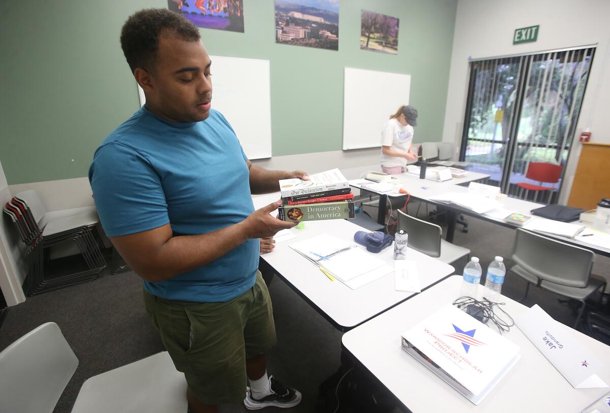 Sterling Meriweather, a Marine stationed at Camp Pendleton, gathers books needed as part of the Warrior-Scholar Project "boot camp" at UC Irvine that aims to help veterans and active military members transition from military service to academic life.