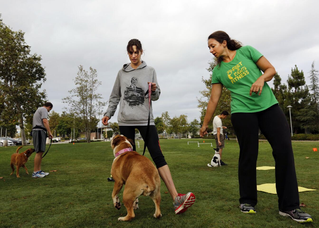 Feet & Paws Fitness instructor Tracy James gives a few training tips to student Sharle Kochman and pup Gordita.